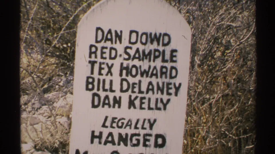 1972 Arizona home-movie frame with the marker filling the view and "LEGALLY HANGED" readable below the names.