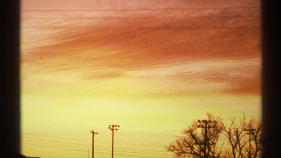 End frame shifts to a warm Arizona sky with utility poles, wires, and tree silhouettes in saturated 8mm color.