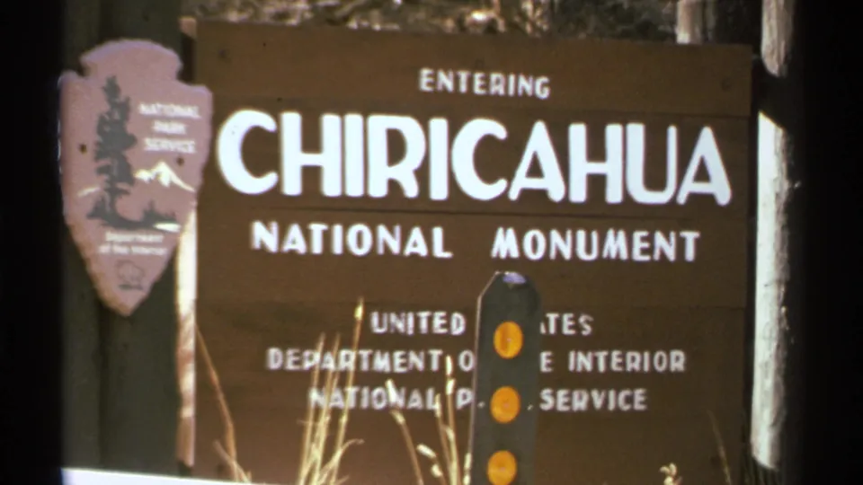 1972 Arizona 8mm view of the Chiricahua National Monument sign, including white text and the NPS arrowhead emblem.