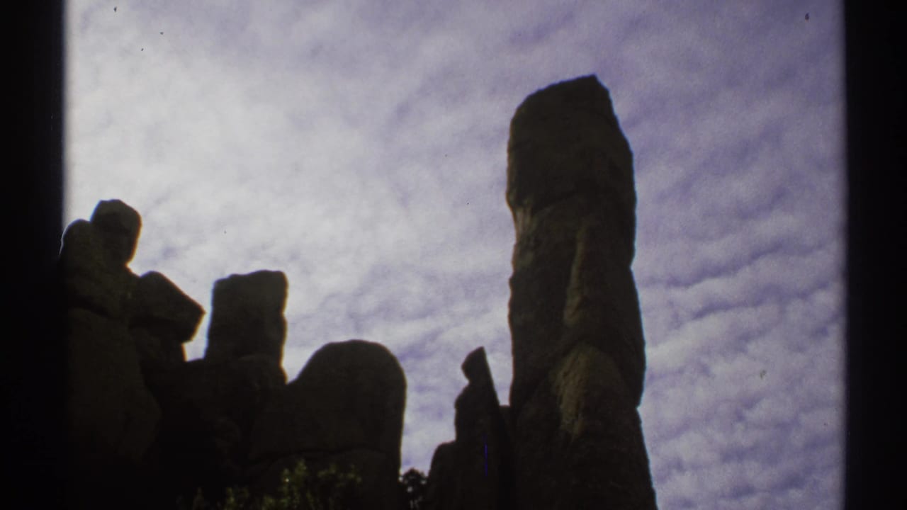 Dark rock spires silhouetted against a cloudy sky.