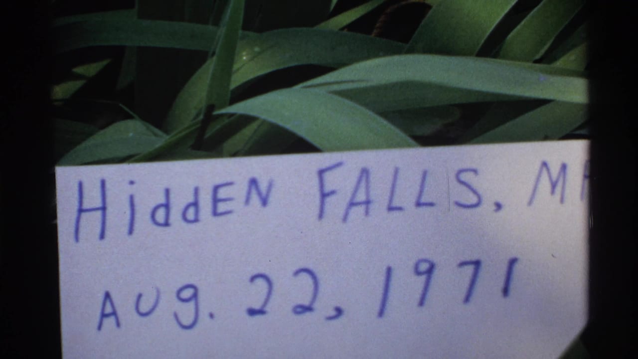 Handwritten Hidden Falls date card held against green leaves.