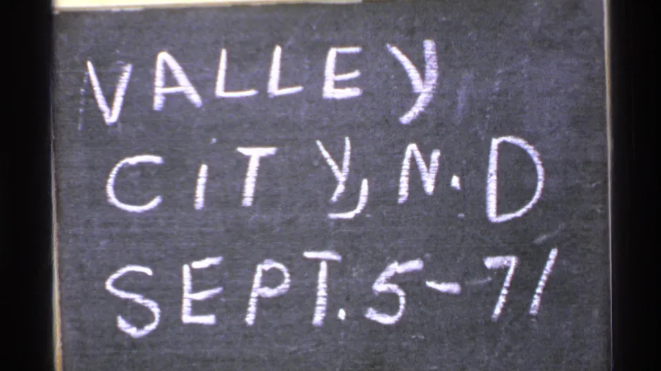 Close 8mm frame of the chalkboard note reading "VALLEY CITY, N.D. SEPT. 5-71" with visible film edge.