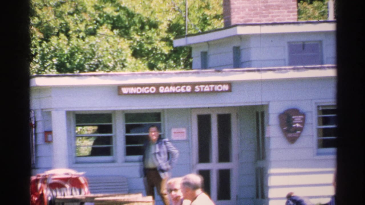 Visitors outside the Windigo Ranger Station with sign and building visible.