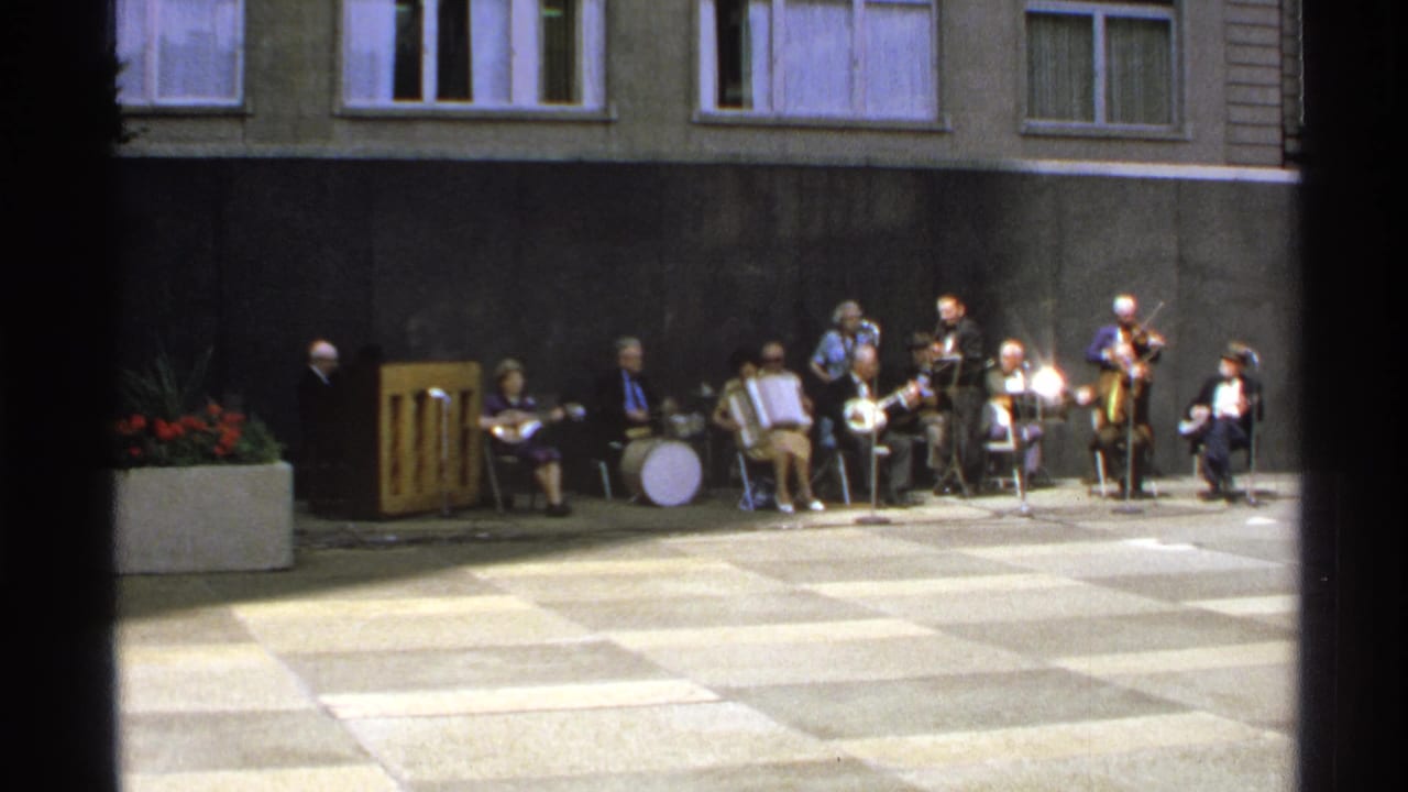1972 Isle Royale courtyard performance with a small band seated in a line under apartment-like windows.
