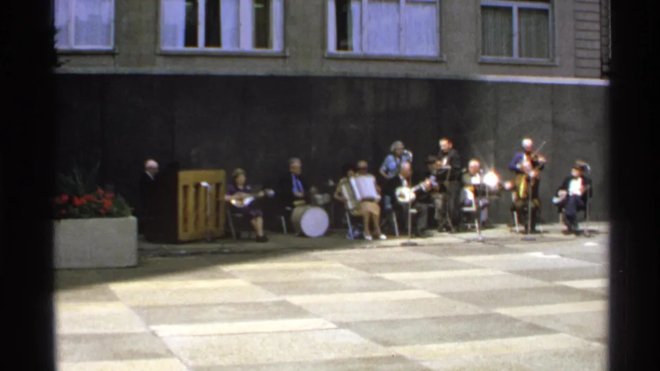 1972 Isle Royale courtyard performance with a small band seated in a line under apartment-like windows.