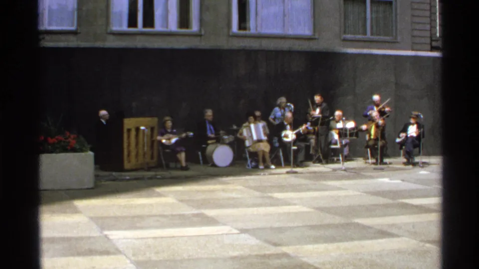 Wide 1972 Isle Royale home-movie view of an outdoor band performing in a paved courtyard.
