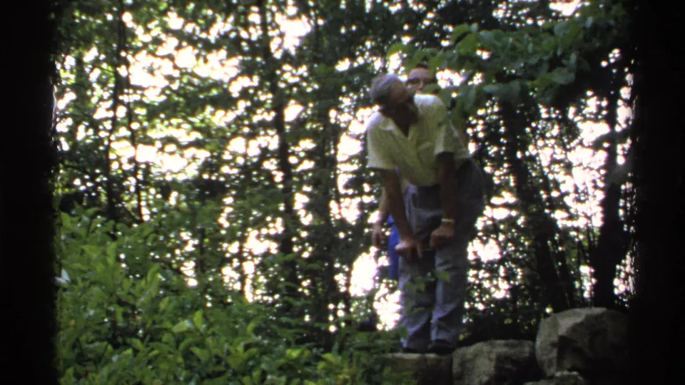 The walkers remain close together on a rocky forest path in the 1972 Isle Royale home-movie scene.