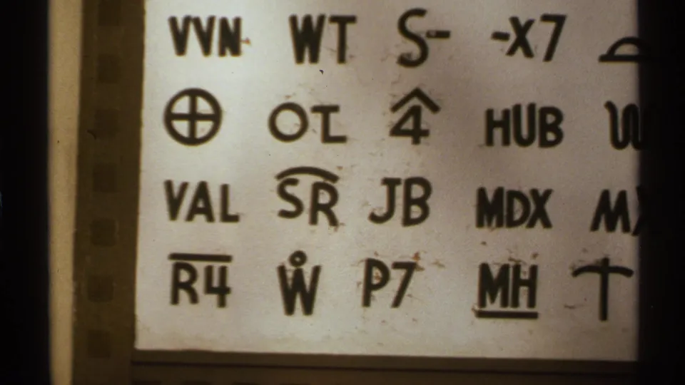 1972 New Mexico home-movie frame with a close crop of the coded white sign and dark film-frame edge.