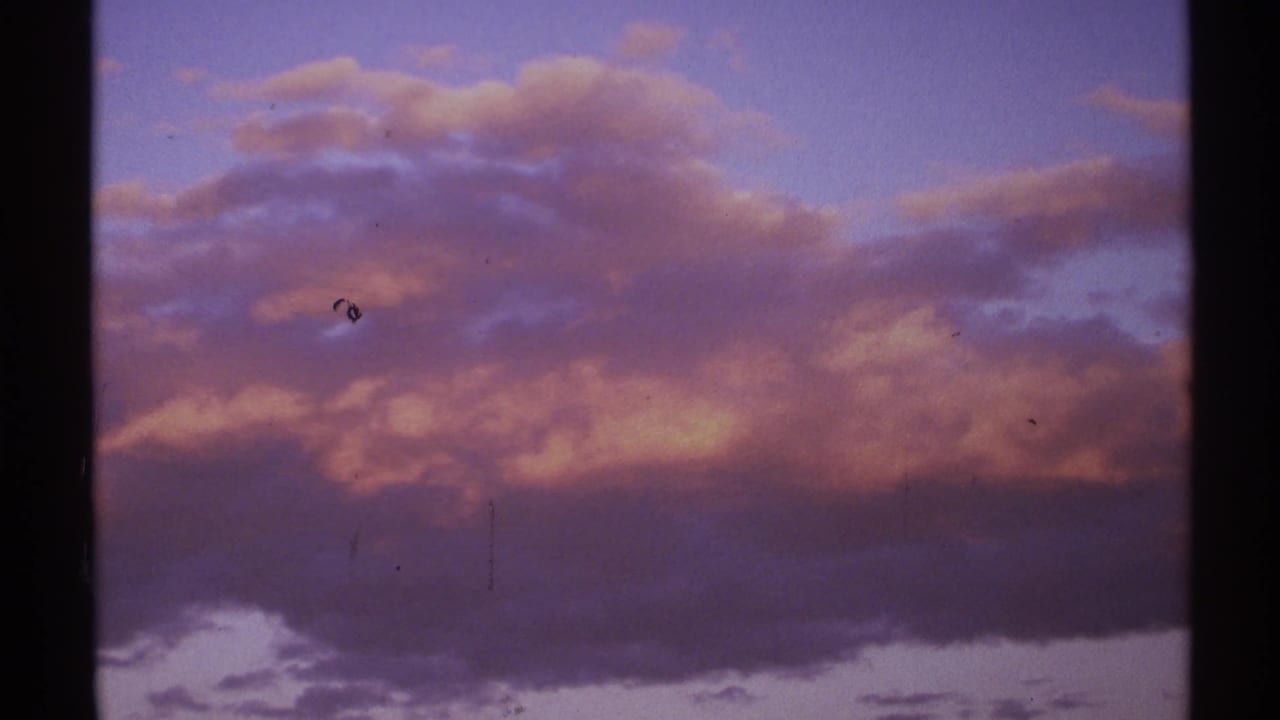 Large purple clouds with warm highlights against a blue twilight sky.