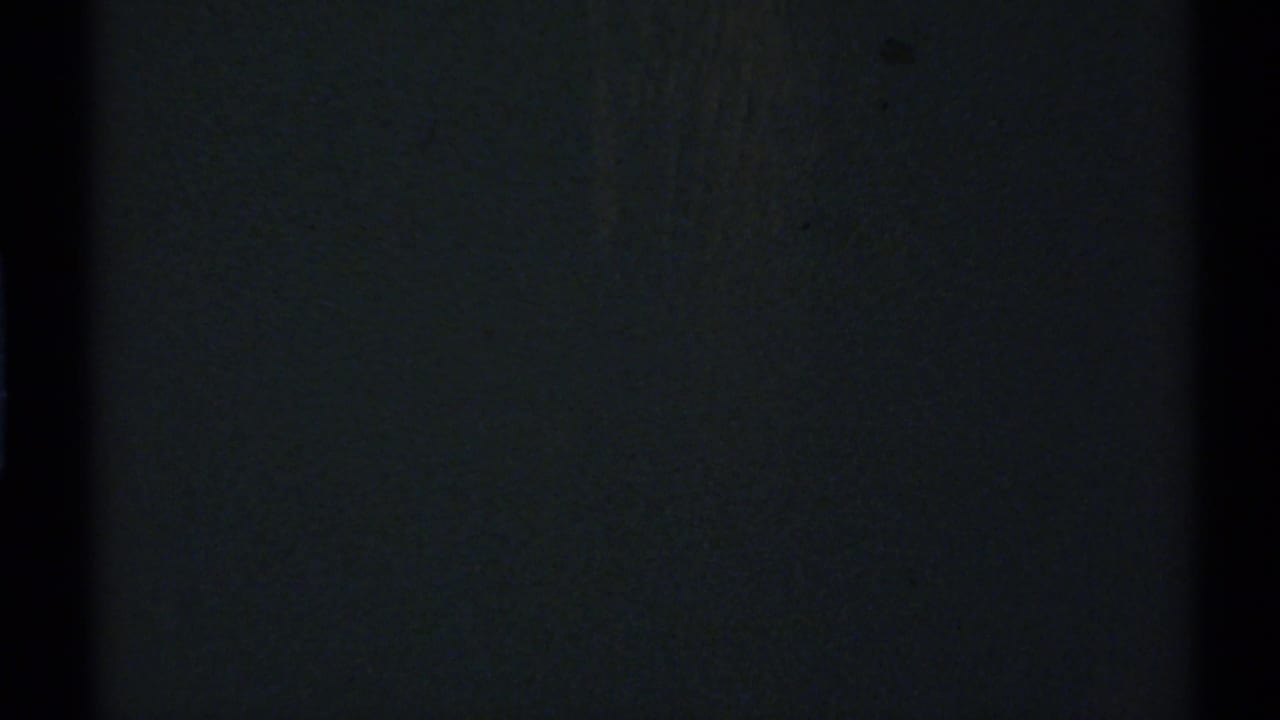 Underexposed 1972 New Mexico 8mm frame showing mostly darkness, grain, and a black vertical film or scan border.