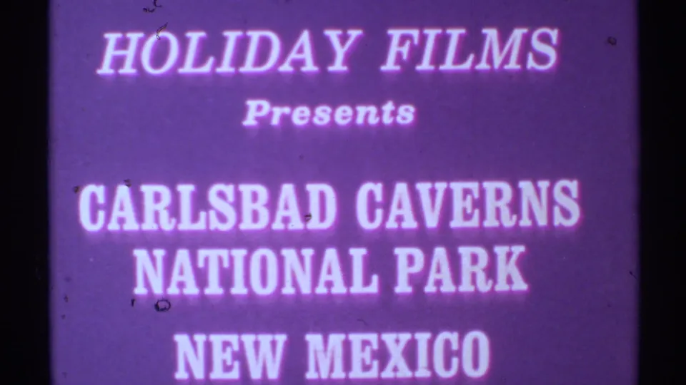 Magenta-purple 8mm title card introduces Carlsbad Caverns National Park in New Mexico under Holiday Films text.