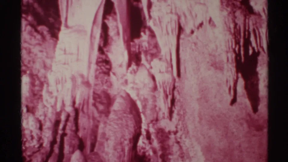 1972 8mm cave view from New Mexico showing pink-tinted rock, stalactites, and soft home-movie exposure.