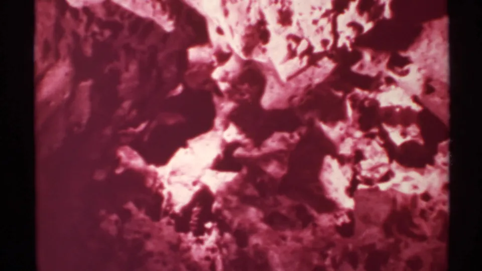1972 New Mexico 8mm frame showing a close, abstract view of rock contours under a strong magenta color shift.