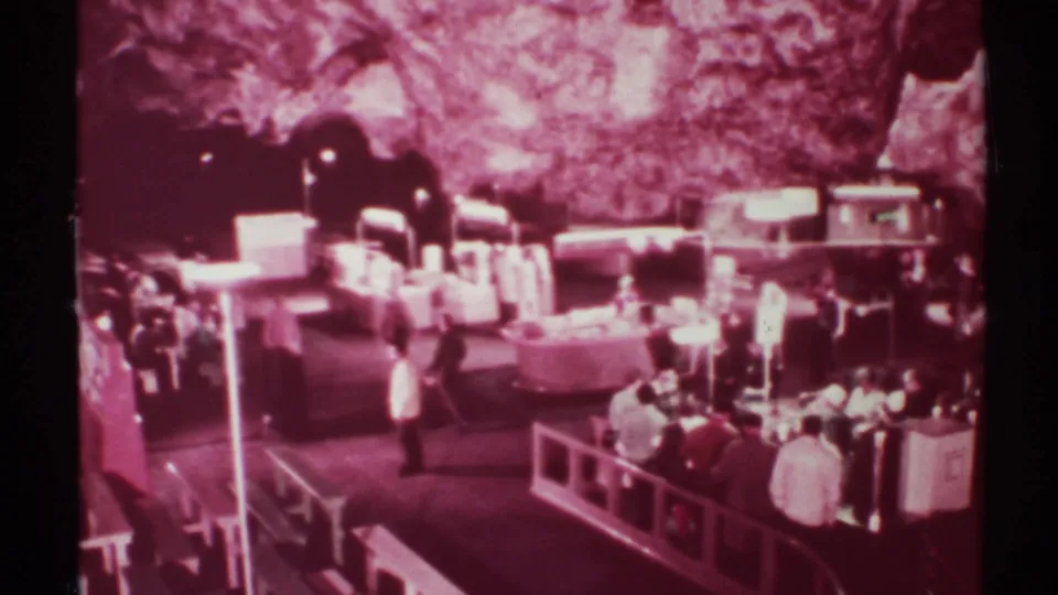 Visitors browse a cavern market or gift area, with counters and seating visible under artificial lighting.