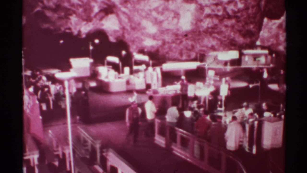 Crowd of visitors stands near display counters under artificial lights in a cavern-like room.