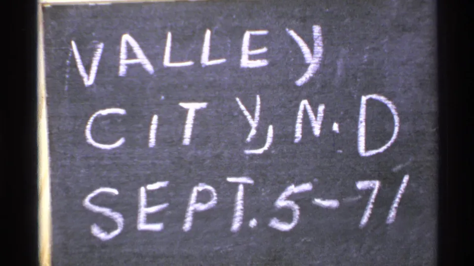 8mm home-movie frame showing the Valley City, N.D. chalk title card before the bridge scene.