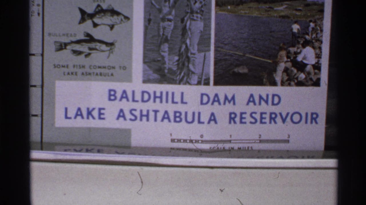 1972 North Dakota 8mm frame showing a blue-and-white Baldhill Dam and Lake Ashtabula Reservoir informational sign.