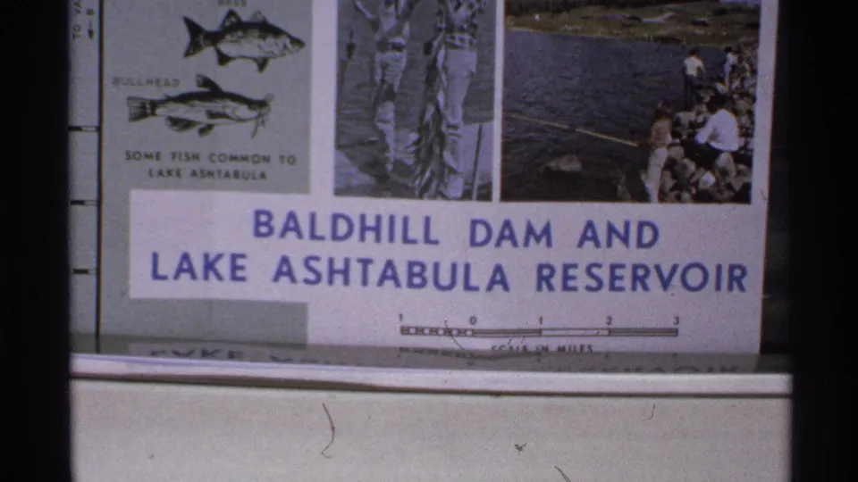 1972 North Dakota 8mm frame showing a blue-and-white Baldhill Dam and Lake Ashtabula Reservoir informational sign.