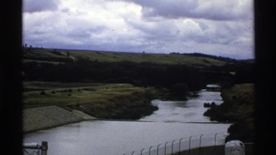 1972 North Dakota 8mm view from Baldhill Dam area toward water, green hills, and the winding Sheyenne River landscape.
