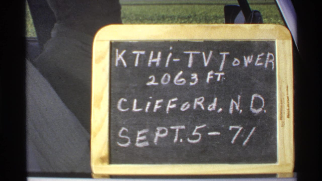 Close view of a chalkboard reading KTHI-TV Tower, 2063 ft., Clifford, N.D., Sept. 5-7/72, beside a vehicle window.