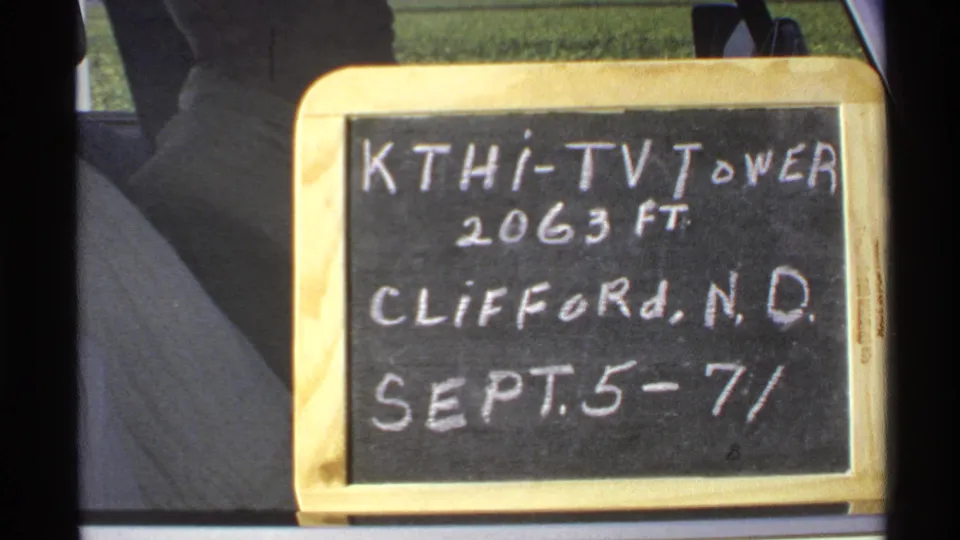 Close-up of the handwritten KTHI-TV tower sign in Clifford, North Dakota, dated Sept. 5-7/72, with car-window framing visible.