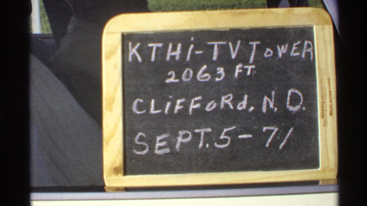 Second view of the KTHI-TV Tower chalkboard sign inside a vehicle window frame.