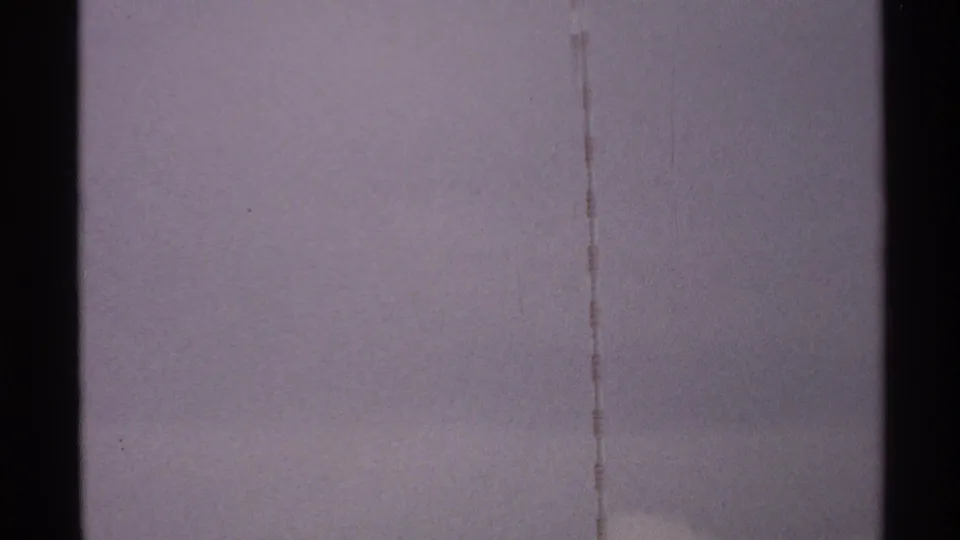 Lower portion of the 8mm view shows a pale sky, a dark vertical edge, and a faint tower or cable line in North Dakota footage from 1972.