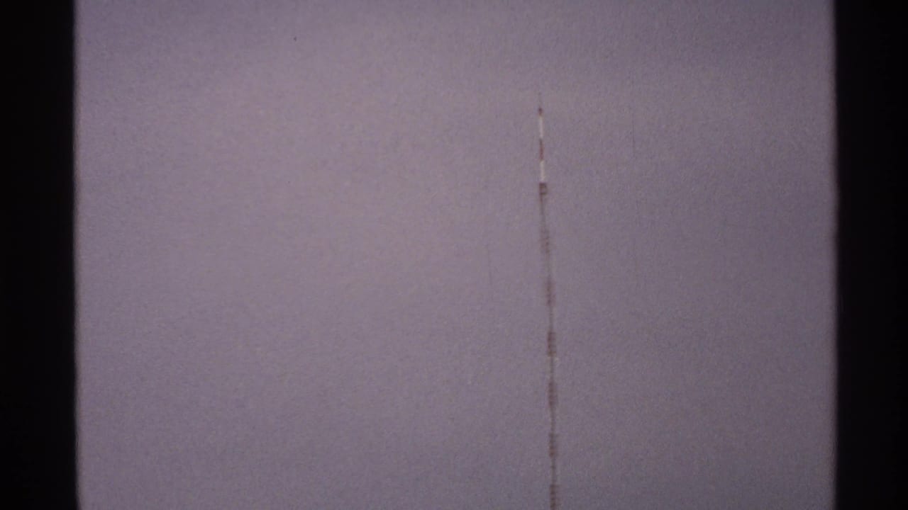 Pale sky with a faint vertical scratch above darker storm clouds.