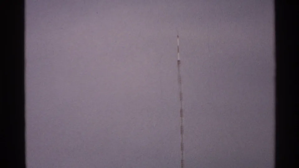 1972 North Dakota 8mm frame showing pale sky, a faint vertical scratch, and storm clouds along the lower edge.