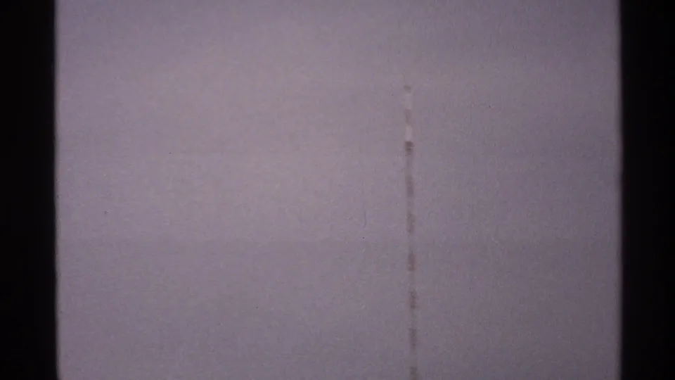 1972 North Dakota 8mm frame with muted purplish sky, a visible vertical scratch, and low storm cloud forms.
