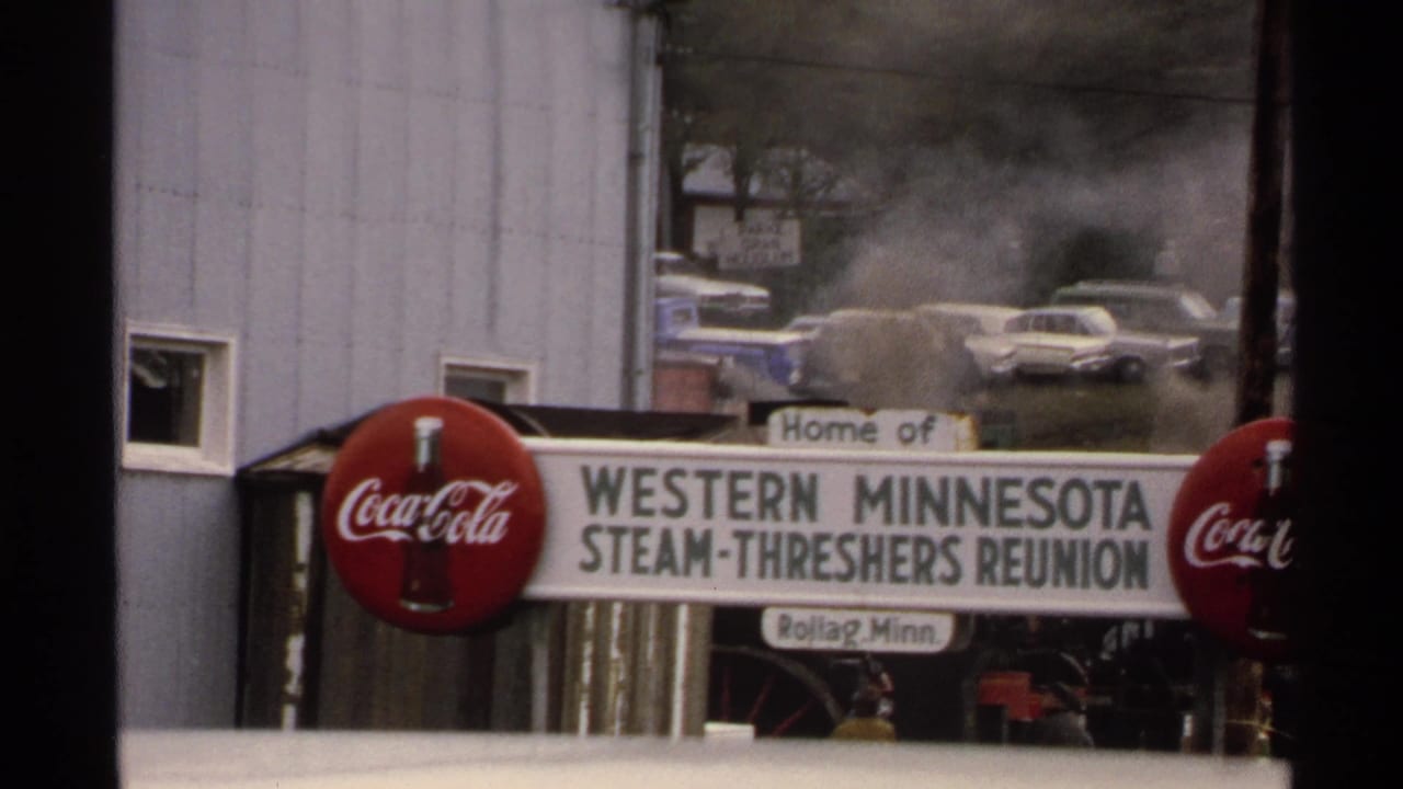 Western Minnesota Steam-Threshers Reunion sign with Coca-Cola logos and steam behind it.