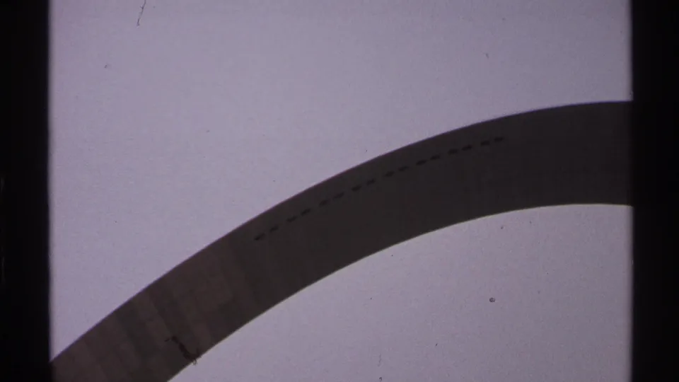 A low-angle 8mm view of the Saint Louis Gateway Arch, with the arch sweeping across a bright, lightly speckled sky.
