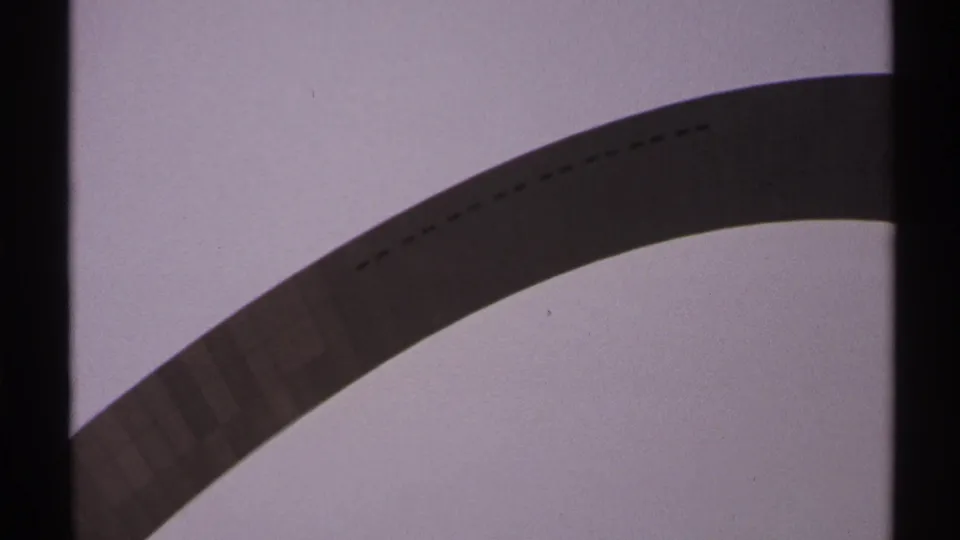 The Gateway Arch is framed low against the sky, with sprocket-area shadows, dust, and 1970s 8mm color texture visible.