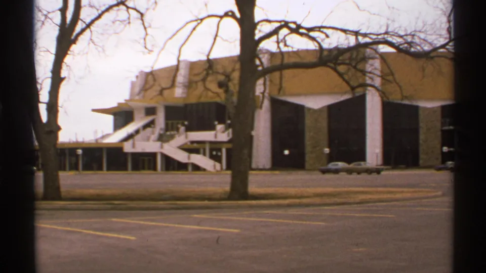 1972 Tulsa footage shows the modernist building facade across a broad street with bare trees and a car near the curb.
