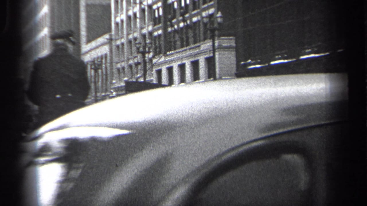 A mounted police officer passes beside a large car hood on a city street.