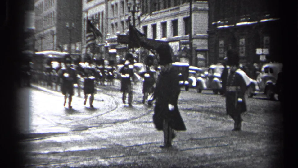 Cleveland 1937 parade scene with an honor guard, American flags, parked cars, and wet streetcar tracks visible.