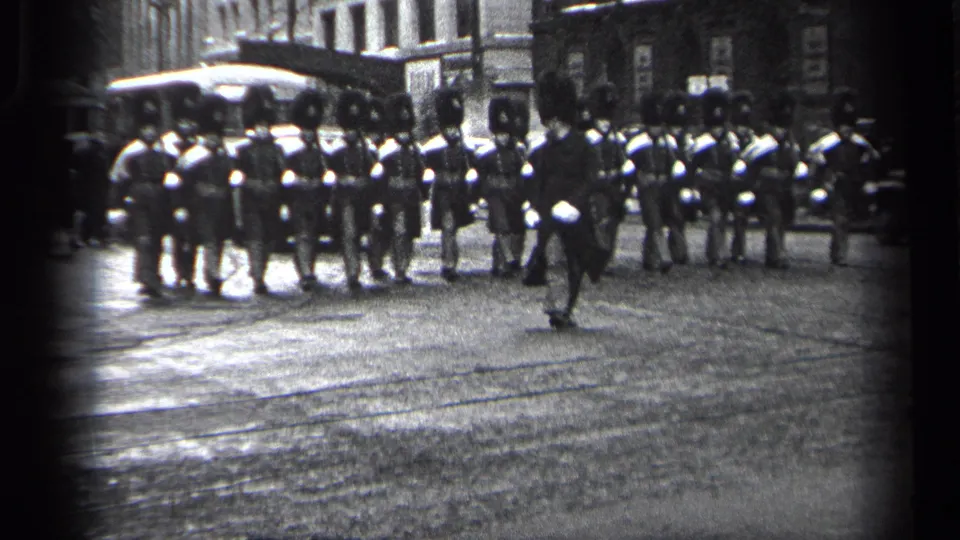 Final 1937 Cleveland frame with uniformed marchers filling the street and a leading figure moving across the foreground.