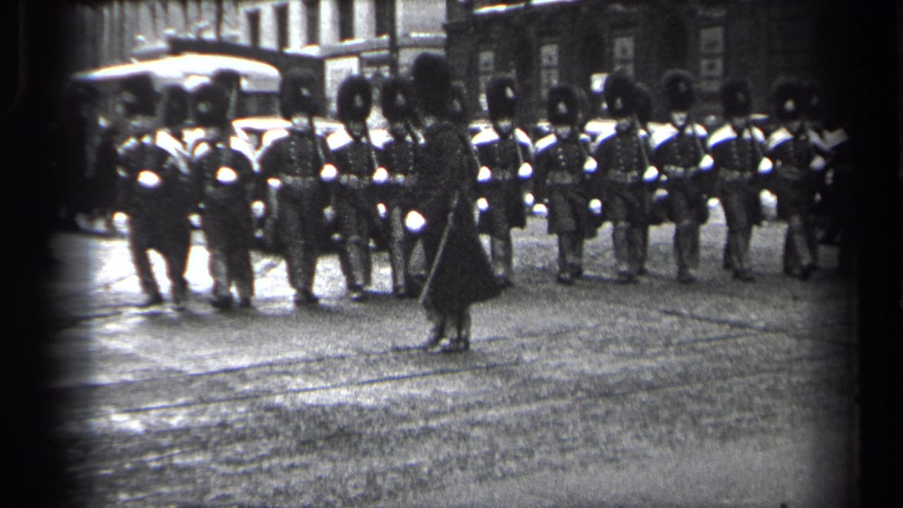 Uniformed marchers face the camera while a figure stands in front of the formation.