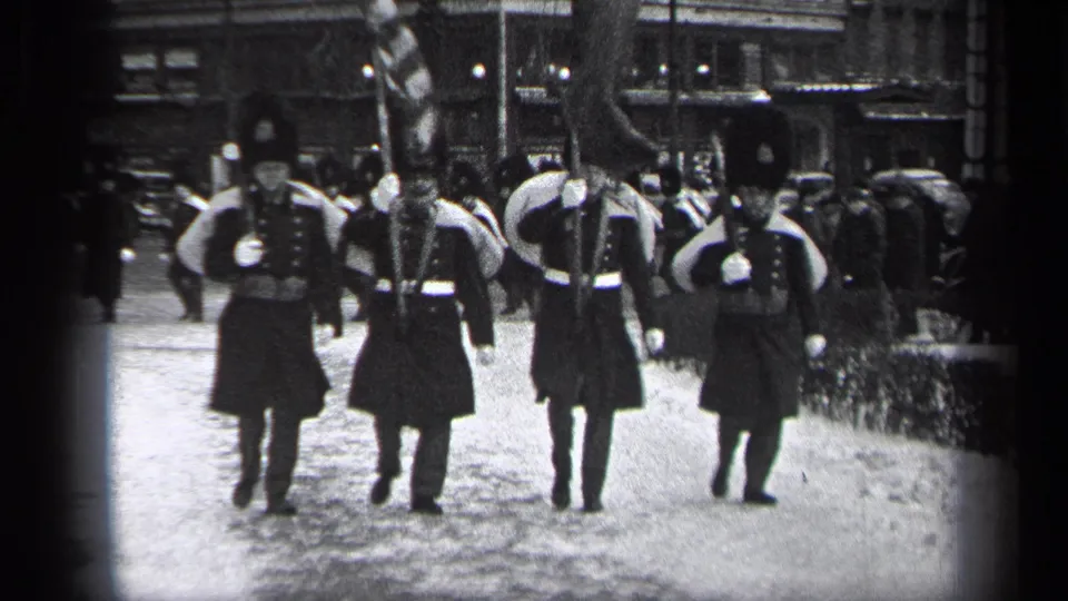 Cleveland parade footage shows uniformed men in formal dress marching toward the camera with flags and rifles.