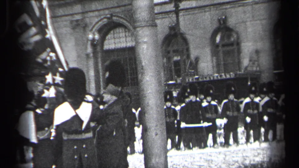 Rows of uniformed personnel stand at attention outside a grand Cleveland building, with a foreground soldier and standard partly visible.