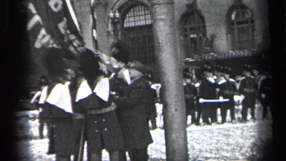 1937 Cleveland ceremony view with uniformed guards, flags, spectators, and a stone building behind a foreground tree trunk.