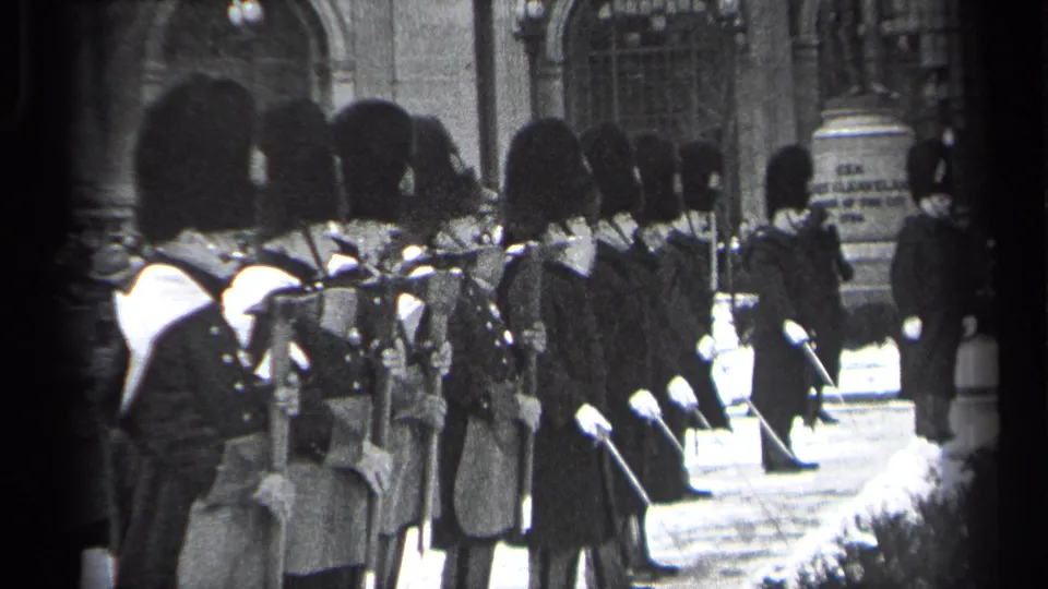Ceremonial guards in tall bearskin-style hats stand at attention in Cleveland, 1937, as filmed from a sidewalk vantage.