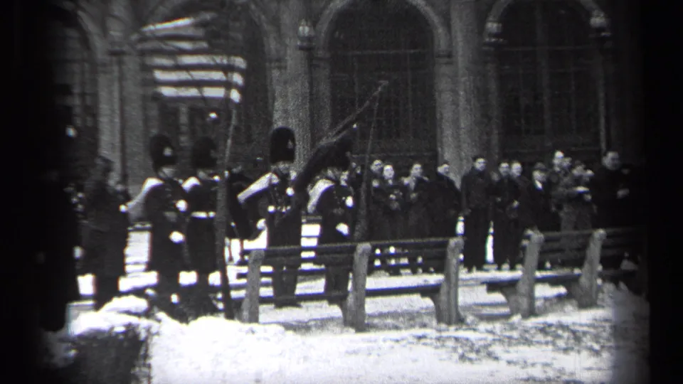 1937 Cleveland footage shows uniformed guards in tall hats saluting an American flag during a snowy outdoor ceremony.