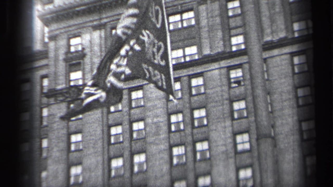 Fluttering flag partially cropped against a multi-story building facade.