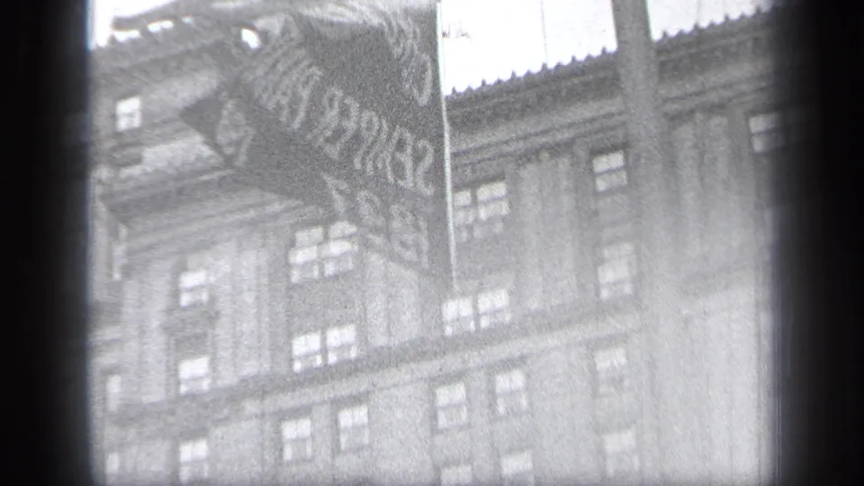 1937 Cleveland footage frame with the flag and building partly washed by exposure and haze.