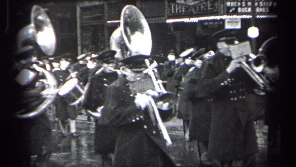 Uniformed brass players in Cleveland, Ohio, appear close to the camera during a 1937 nighttime street performance.