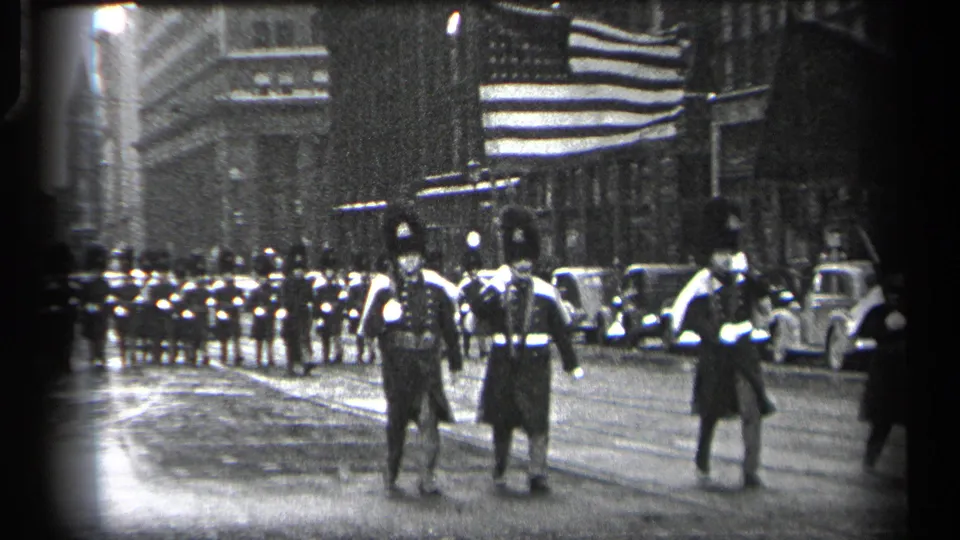 1937 Cleveland street parade frame showing uniformed participants walking toward the camera with a larger formation behind them.