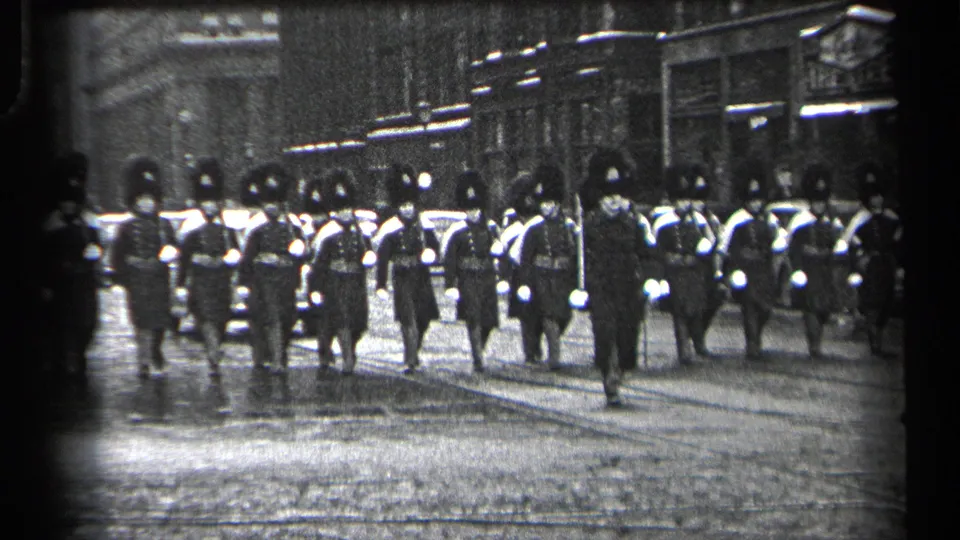 Closer view of the 1937 Cleveland parade, with uniformed participants marching in rows along a wet city street.