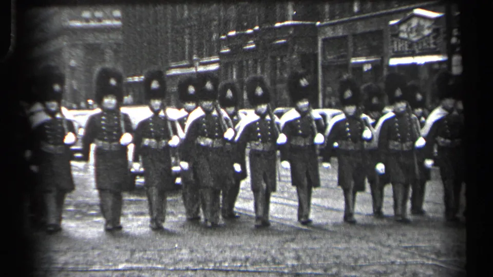 British Guards in ceremonial uniforms march in formation through a Cleveland street scene, supported by supplied 1937 metadata.