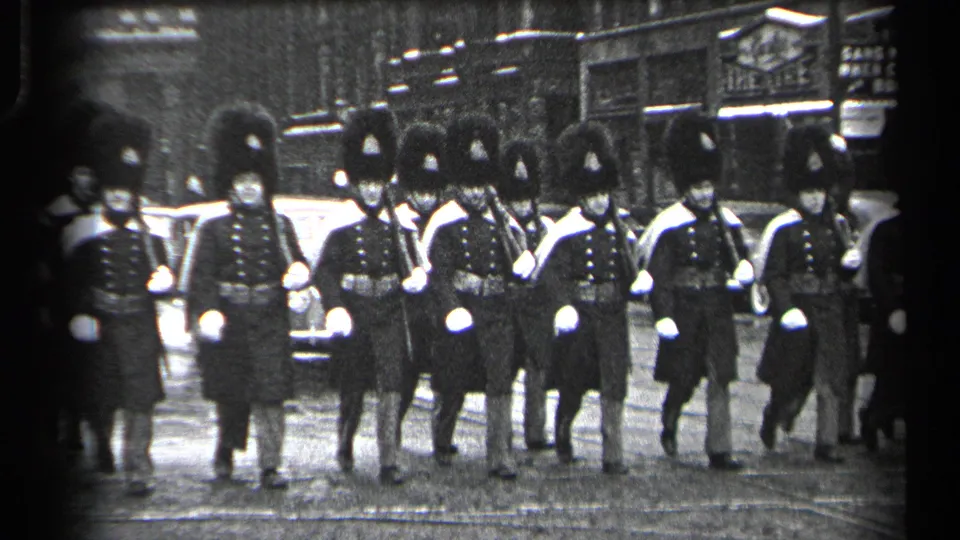 The 8mm frame shows a closer Cleveland street view of British Guards marching in step in ceremonial dress.